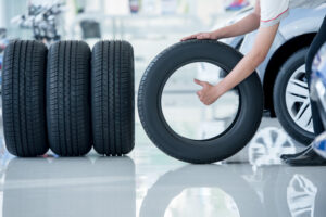 A photo of someone rolling tires on a dealership floor.