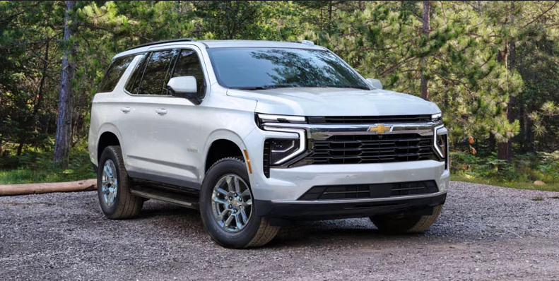 A silver 2025 Chevrolet Tahoe parked on a gravel driveway.
